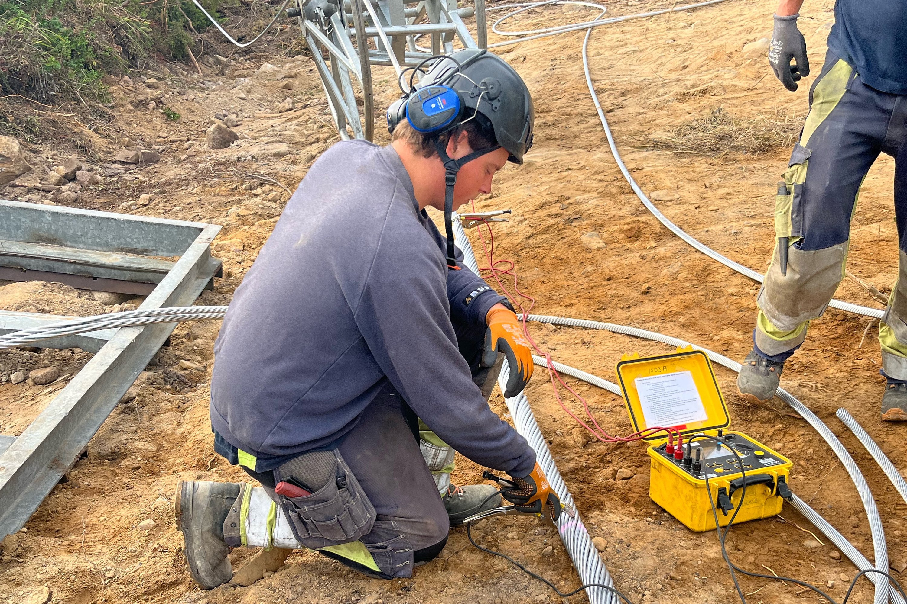 Linus Romilson, montör på Vattenfall Services Nordic, som har entreprenaden på Svk:s 220 kV linbyte utanför Valbo väster om Gävle, preparerar den nya varmtåligare linan ACCR innan upphängning. Foto: Tommy Alvar.