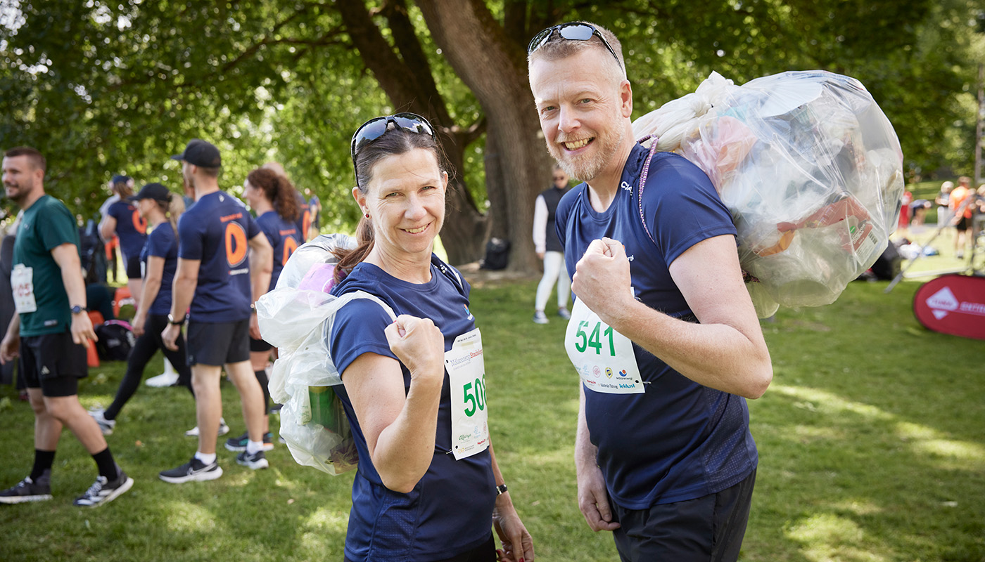 Carin Lidman och Niklas Gunnar, styrelseordförande respektive koncernchef på Mälarenergi, med sitt eget plastavfall på ryggen. Foto: Mälarenergi.